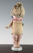 After Rose O`Neill. An all bisque Kewpie doll, early 20th century, with typical `strung` arms and