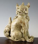 A Japanese pottery model of a Kara shi-shi, 19th century, in seated pose, its head turned to the