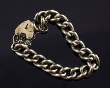 A heavy 9ct gold curb link bracelet with heart shaped padlock clasp, 74 grams.