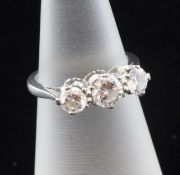 An 18ct white gold and graduated three stone diamond ring, the round cut stones with an