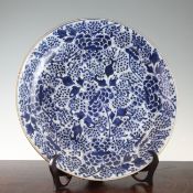 A Chinese blue and white dish, 17th century, painted with flowers and berries, the underside with