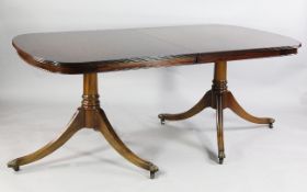 A George III style mahogany extending twin pedestal dining table, on moulded downswept supports, W.