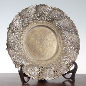 An Indonesian Yogya silver dish, early 20th century, with flower embossed wrythen fluted border,