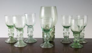 A harlequin set of seven late Georgian pale green glass roemers, and a humpen type glass, the