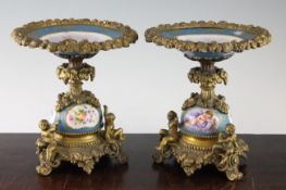 A pair of Sevres style painted porcelain and ormolu mounted tazza, the circular dished tops