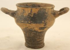 A Mycenaeum pottery skyphos, of baluster shape with a pair of looped handles, partial black glaze,