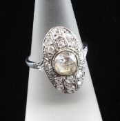 An early 20th century platinum and diamond set cluster ring, of oval form, with central rose cut