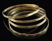 Two pairs of Middle Eastern high carat gold bangles, with bright cut engraved decoration, 73 grams.