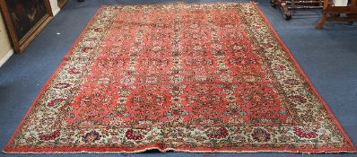 A Tabriz carpet, with seven rows of foliate motifs on a coral red ground, with three row border, 9ft