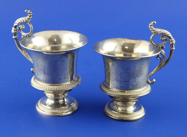 A pair of 19th century Austro-Hungarian silver cups, of urn form, with ornate scroll handles,