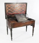 An early 19th century padouk brass bound military campaign desk, the hinged top revealing a fitted