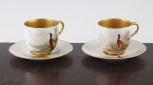 Two James Stinton Royal Worcester gilded tea cups and saucers, c. 1910, the painted exteriors and