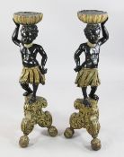 A pair of 18th century Italian painted `Blackamoor` torcheres, each holding a fluted bowl aloft, H.