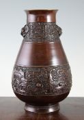 A Japanese bronze archaistic pear shaped vase, 19th century, decorated with bands of grotesque masks