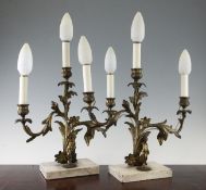 A pair of late 19th century ormolu three branch candelabra, modelled with scrolling floral