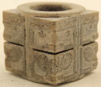 A Chinese archaistic grey stone song, of square form around a cylindrical aperture, carved in low