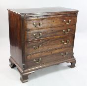 A George III mahogany chest, of four long graduated drawers with brushing slide between reeded