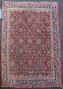 A North West Persian carpet, with geometric field of floral motifs, on a red ground, with multi