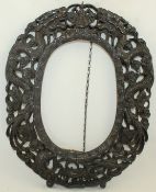 A Chinese rosewood oval frame, late 19th century, boldly carved and pierced with two chi-dragons,