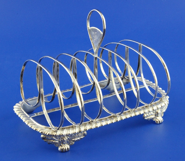 A George IV silver seven bar toastrack, with engraved initials and gadrooned border, on foliate