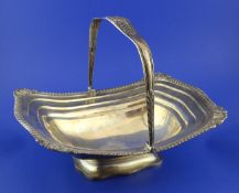 A George III silver cake basket, of rounded rectangular boat shape, with gadrooned border and