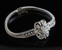 An 18ct white gold and diamond bracelet, with pierced central foliate motif set with round cut