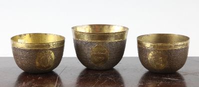 A pair of 18th century German parcel gilt copper toasting cups engraved with mottos and armorials,