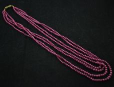 A four strand graduated ruby bead necklace, with gilt metal barrel clasp, 20.5in.