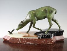 A French Art Deco green patinated bronze model of a deer, on a shaped marble and onyx stepped