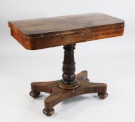 An early 19th century rosewood folding card table, with swivel top, on turned central column and