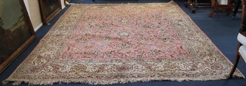 A Tabriz carpet, with field of scrolling foliage, on a coral ground, with five row foliate border,