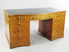A George III style satinwood inlaid serpentine kneehole desk, with green leather skiver above an