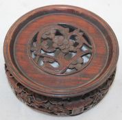 A Chinese rosewood stand, late 19th century, carved and pierced with blossoming prunus branches,