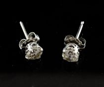 A pair of white gold and solitaire diamond ear studs, the round cut stones with a combined weight of