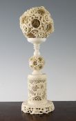 A large Chinese ivory concentric puzzle ball and stand, early 20th century, the exterior of the ball