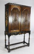 An early 18th century oak cabinet on stand, with two arched panel doors with chequer inlay and