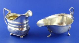 A George III demi fluted silver cream jug, of shaped rectangular form, on ball feet, James