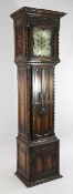 An Edwardian Jacobean revival oak eight day longcase clock, the 12 inch square silvered dial