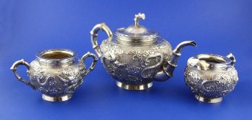 A late 19th/early 20th century Chinese three piece silver tea, of squat circular form, with faux