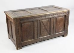 An 18th century oak coffer, with triple panelled front and simple geometric carving, W.4ft 2in.