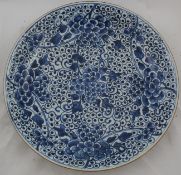 A Chinese blue and white dish, 17th century, painted with flowers and berries, the underside with