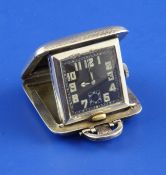 A 1930`s engine turned silver Sapho travelling timepiece, of square form, with hinging folding