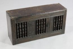 A 17th century fruitwood and pine livery cupboard, with single hinged door and baluster turned