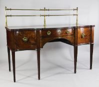 A George III mahogany serpentine sideboard, the back with brass rail above two drawers and single