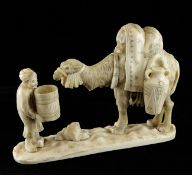 A Japanese sectional walrus ivory group of an arab man feeding water to a camel, 26.5cm.