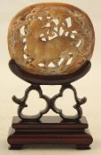 A Chinese russet jade plaque, Ming Dynasty, carved in openwork with a qilin amid foliate scrolls,