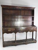 An 18th century oak dresser, the back fitted with two shelves over three frieze drawers above open