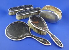 A George V tortoiseshell and silver pique four piece dressing set, comprising a mirror and three