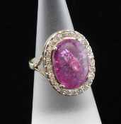 A 9ct gold, pink sapphire and diamond set cluster ring, the oval cut sapphire weighing 9.64ct and