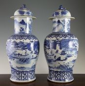 A pair of Chinese blue and white `landscape` baluster vases and covers, 19th century, each well